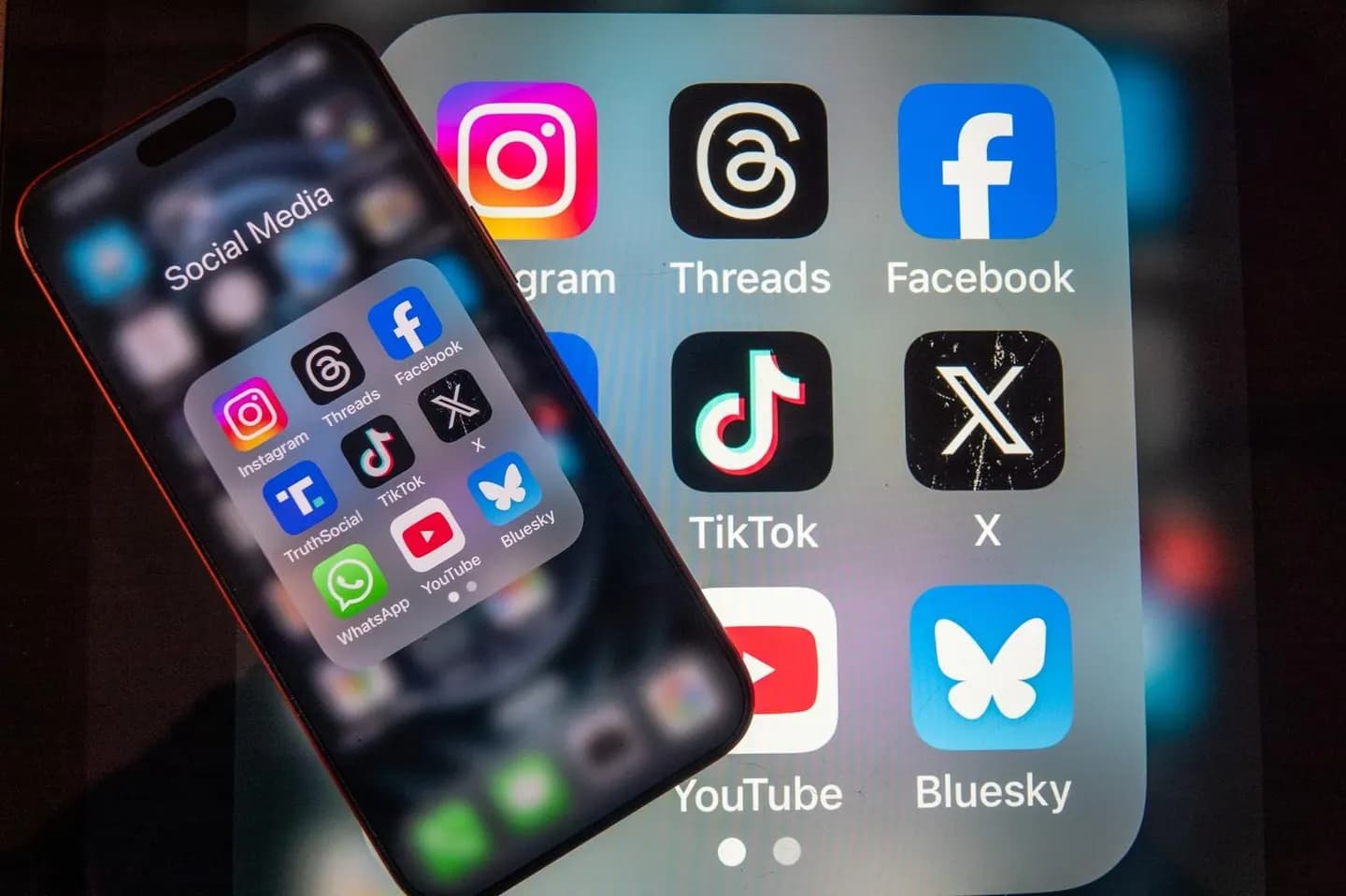 Redes sociales y salud emocional. Imagen de celular y fondo de logos de redes sociales.